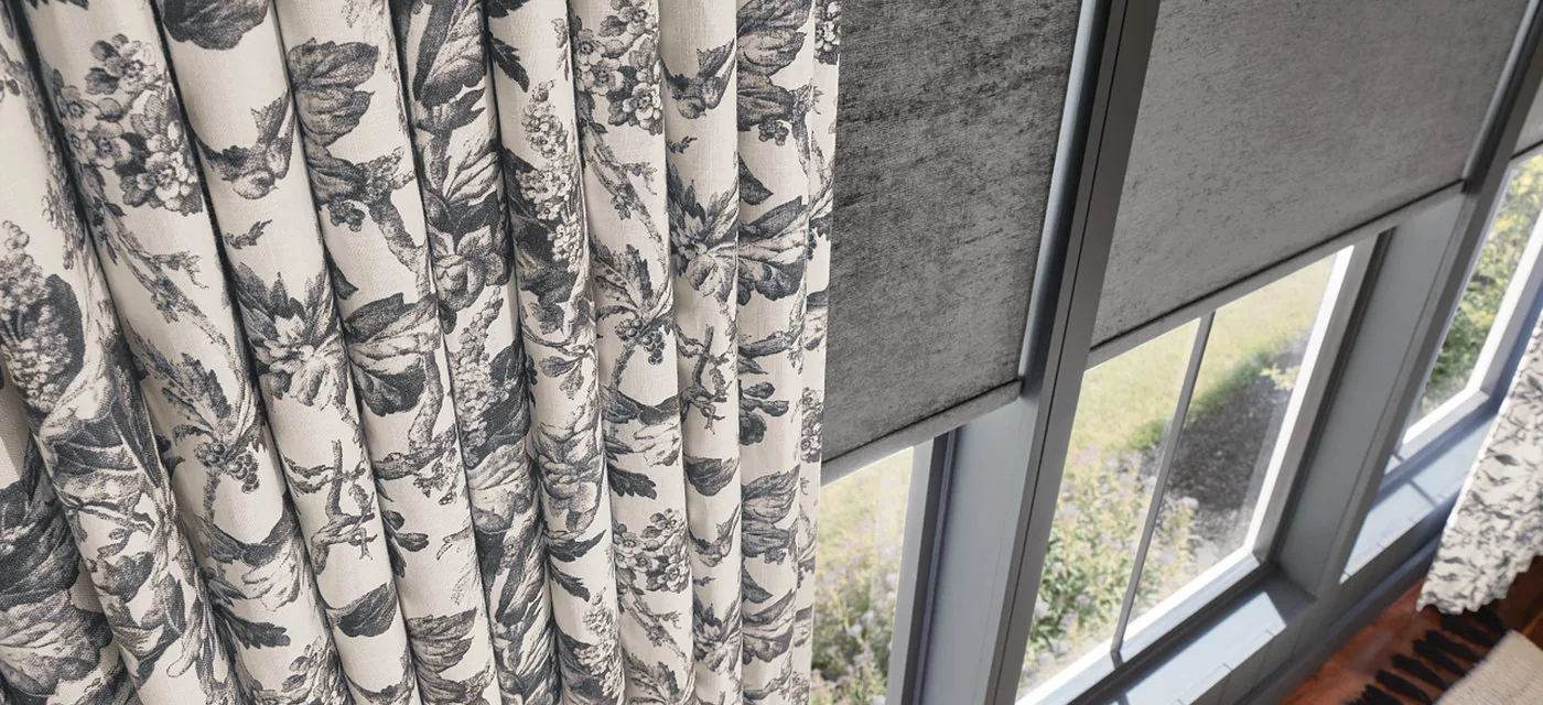 Custom floral drapes paired with a roller shade in a South Jordan home