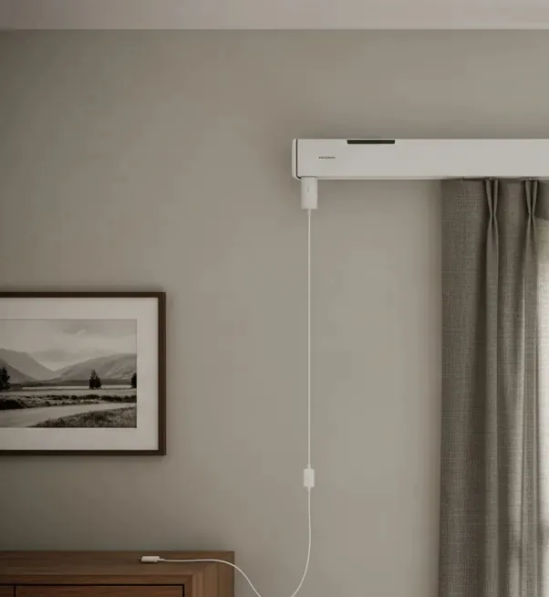 Motorized drapery track mounted above a window