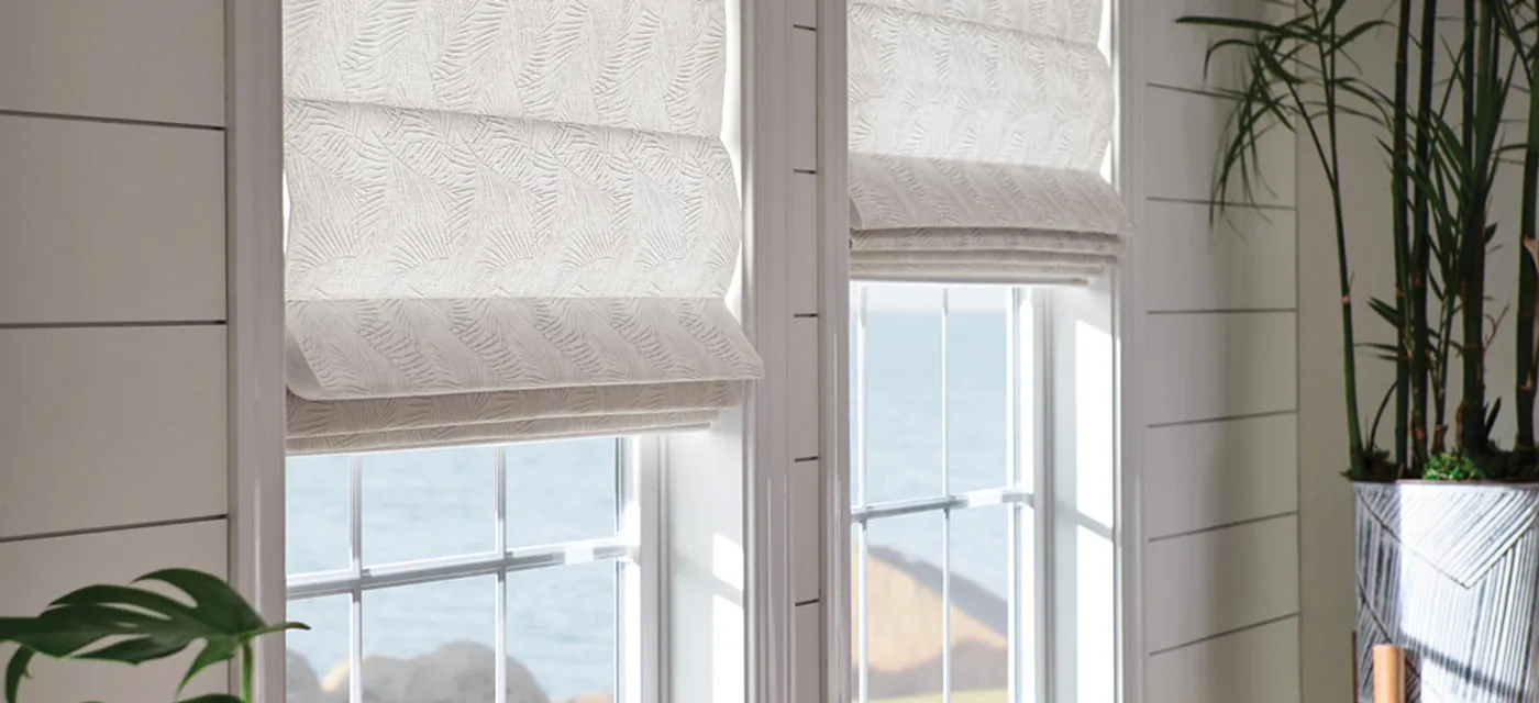 White Roman shades on coastal-style windows
