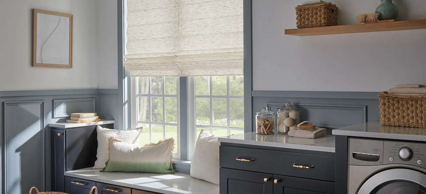 Woven wood Roman shade over a mudroom window seat in South Jordan, Utah