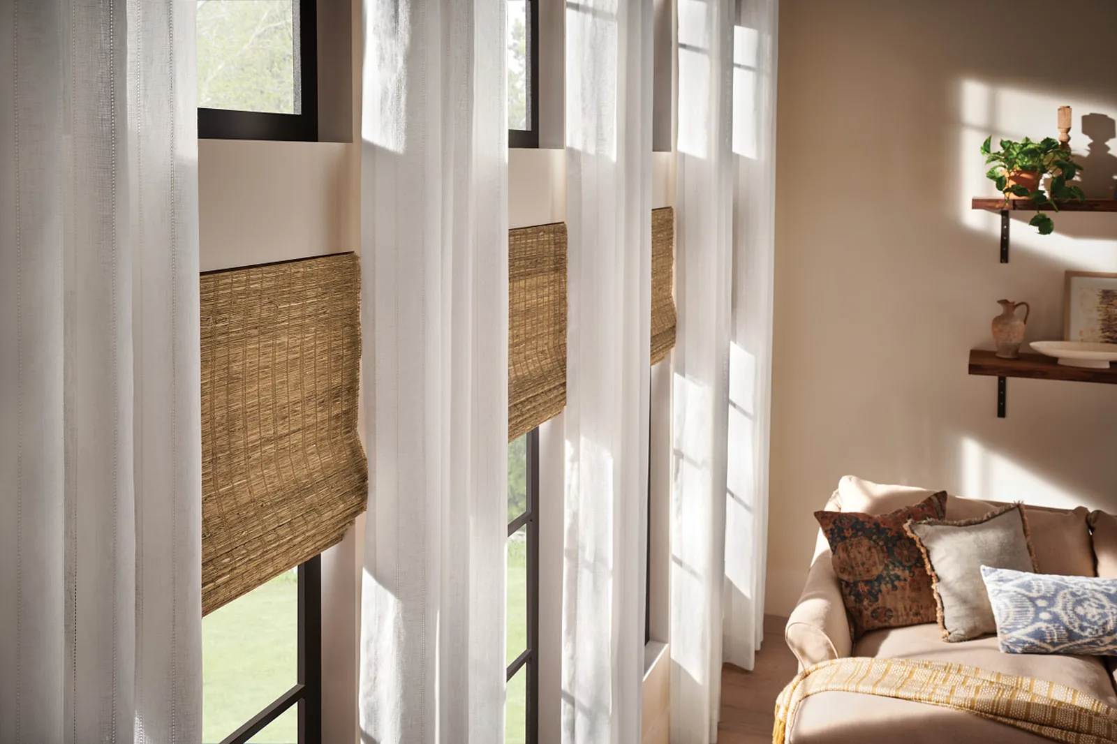 Motorized drapery layered over woven shades